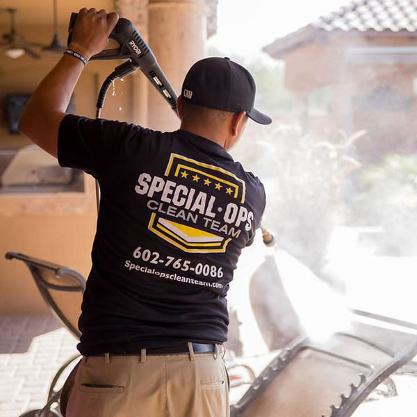 A Special Ops Clean Team member pressure washing patio furniture in the Phoenix, AZ area